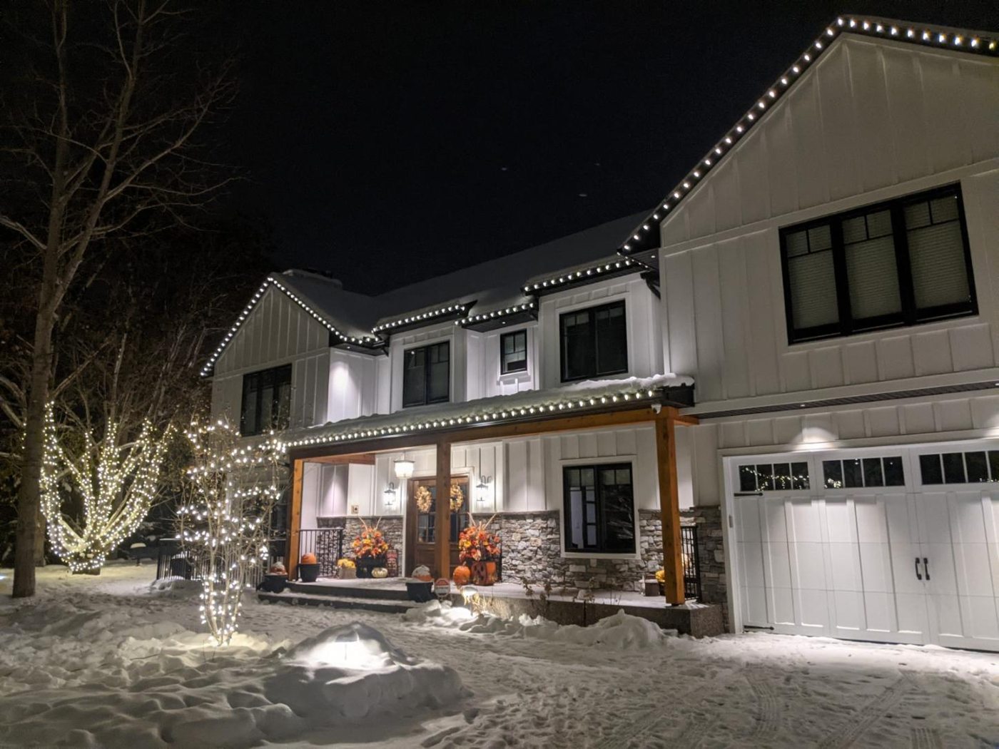 Home with warm lighting and lit trees